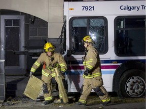 Firefighters clean up after a crash between a city bus and a pickup truck at the intersection of McKenzie Towne Gate and McKenzie Towne Link SE in Calgary, Alta., on Thursday, Feb. 18, 2016. Although there were no major injuries, the collision did cause the bus to crash through a length of fence and trees before hitting a condo complex.