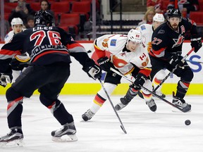 Carolina Hurricanes' John-Michael Liles (26) and Justin Faulk (27) defend as Calgary Flames' Sam Bennett (93) skates with the puck during the first period onJan. 24, 2016.