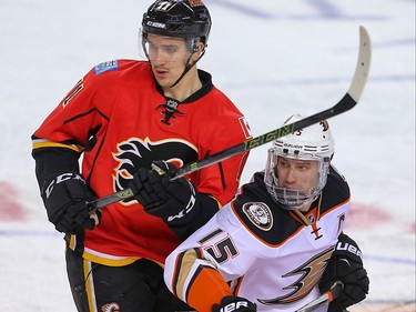 Calgary Flames Mikael Backlund and Ryan Getzlaf of the Anaheim Ducks battle for a loose puck during NHL hockey in Calgary, Alta. on Monday February 15, 2016. Al Charest/Postmedia