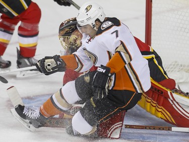 Andrew Cogliano of the Anaheim Ducks falls in front of Calgary Flames goalie Jonas Hiller in Calgary, Alta., on Monday, Feb. 15, 2016. Lyle Aspinall/Postmedia Network