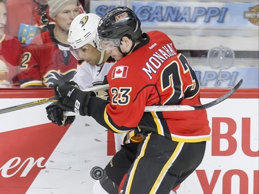 Sean Monahan of the Calgary Flames collides with Andrew Cogliano of the Anaheim Ducks in Calgary, Alta., on Monday, Feb. 15, 2016. Lyle Aspinall/Postmedia Network