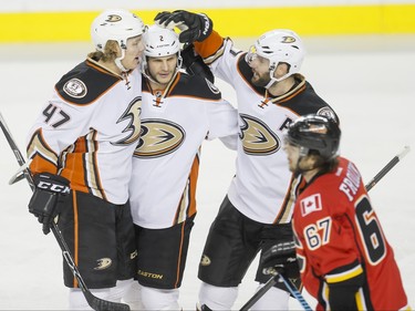 (L-R) Hampus Lindholm, Kevin Bieksa and Ryan Kesler of the Anaheim Ducks celebrate a tying 1-1 goal near Michael Frolik of the Calgary Flames in Calgary, Alta., on Monday, Feb. 15, 2016. Lyle Aspinall/Postmedia Network