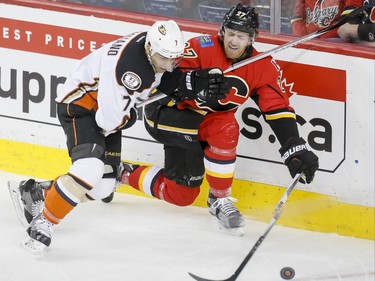 Dougie Hamilton of the Calgary Flames takes a stick to the throat from Andrew Cogliano of the Anaheim Ducks in Calgary, Alta., on Monday, Feb. 15, 2016. Lyle Aspinall/Postmedia Network