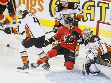 Mikael Backlund of the Calgary Flames slips in front of Anaheim Ducks goalie Frederik Andersen and near defenders Cam Fowler and Kevin Bieksa in Calgary, Alta., on Monday, Feb. 15, 2016. Lyle Aspinall/Postmedia Network