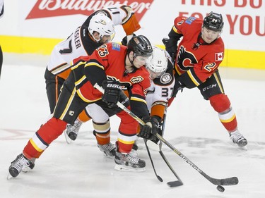 Sean Monahan and Jiri Hudler of the Calgary Flames go for a puck with Ryan Kesler and Nick Ritchie of the Anaheim Ducks in Calgary, Alta., on Monday, Feb. 15, 2016. Lyle Aspinall/Postmedia Network