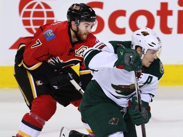 Calgary Flames TJ Brodie battles against Zach Parise of the Minnesota Wild during NHL hockey in Calgary, Alta., on Wednesday, February 17, 2016. Al Charest/Postmedia