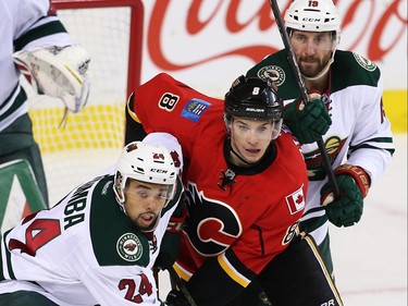 Calgary Flames Joe Colborne battles against Matt Dumba and Jarret Stoll of the Minnesota Wild during NHL hockey in Calgary, Alta., on Wednesday, February 17, 2016. Al Charest/Postmedia