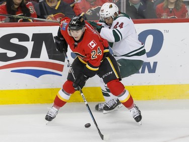 Jiri Hudler of the Calgary Flames battles with Matt Dumba of the Minnesota Wild in Calgary, Alta., on Wednesday, Feb. 17, 2016. Lyle Aspinall/Postmedia Network