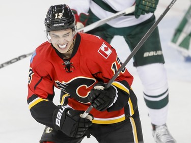 Johnny Gaudreau of the Calgary Flames grimaces after hurting his hand in the first period against the Minnesota Wild in Calgary, Alta., on Wednesday, Feb. 17, 2016. Lyle Aspinall/Postmedia Network