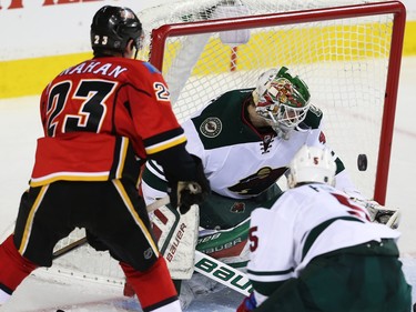 Minnesota Wild Devan Dubnyk makes a save on a shot by Sean Monahan of the Calgary Flames during NHL hockey in Calgary, Alta., on Wednesday, February 17, 2016. Al Charest/Postmedia