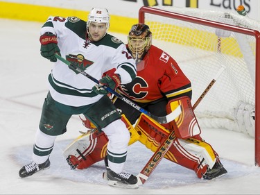 Nino Niederreiter of the Minnesota Wild eyes a play in front of Calgary Flames goalie Jonas Hiller in Calgary, Alta., on Wednesday, Feb. 17, 2016. Lyle Aspinall/Postmedia Network