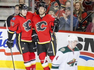David Jones of the Calgary Flames celebrates his goal with teammate Micheal Ferland near Mike Reilly of the Minnesota Wild in Calgary, Alta., on Wednesday, Feb. 17, 2016. Lyle Aspinall/Postmedia Network