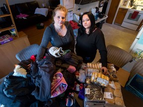 Danielle Stewart and Tammi Dagley, organizers of YYC Helping Homeless, pose for a photo with donated food and clothing at Dagley's home in Calgary on Tuesday, Feb. 2, 2016.