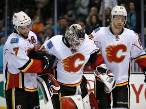 Calgary Flames goalie Karri Ramo, center, is helped off the ice by T.J. Brodie (7) and Dougie Hamilton after a collision with San Jose Sharks' Joonas Donskoi during the third period of an NHL hockey game in San Jose, Calif., Thursday, Feb. 11, 2016. Ramo will miss the rest of the season after suffering a torn anterior cruciate ligament and meniscus damage in his left knee during a game last week. THE CANADIAN PRESS/AP/Tony Avelar
