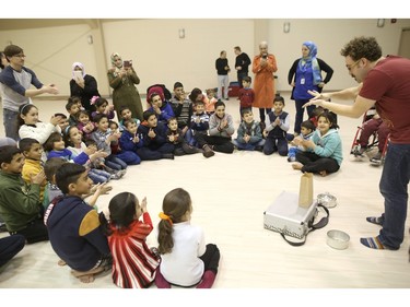 James Jordan, with the Green Fools, right, does magic tricks for Syrian refugee children play at a rec-centre in Calgary, Ab., on Tuesday February 23, 2016. Leah Hennel/Postmedia
