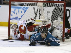 San Jose Sharks right wing Joonas Donskoi (27) collides with Calgary Flames goalie Karri Ramo during the third period of an NHL hockey game in San Jose, Calif., Thursday, Feb. 11, 2016. The Flames defeated the Sharks 6-5 in a shootout.