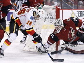 Calgary Flames' Josh Jooris  has his shot blocked by Arizona Coyotes' Louis Domingue during the first period of an NHL hockey game Friday, in Glendale, Ariz.