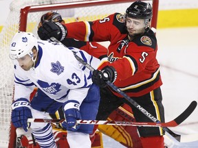 Toronto Maple Leafs' Nazem Kadri, left is pushed away from the Calgary net by Calgary Flames' Mark Giordano during second period on Tuesday. (Larry MacDougal/Canadian Press)