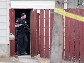 Police look for a suspect at the scene of a stabbing on Fallswater Road N.E. in Calgary on Thursday, Feb. 18, 2016. Leah Hennel/Postmedia