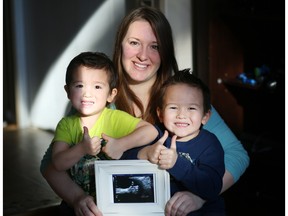 Nicole Kim holds her 20 week ultrasound of her baby, due in June, giving the thumbs up, with her two boys Kaeden, 3, left and Tyson, 5, at their home in Calgary, Ab., on Tuesday, Feb. 2, 2016.