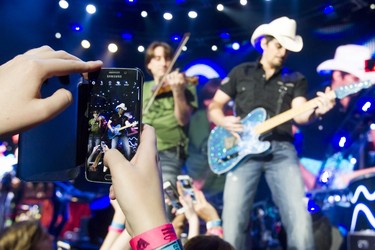 Country star Brad Paisley is nabbed on a smartphone as he performs at the Scotiabank Saddledome in Calgary, Alta., on Thursday, Feb. 18, 2016. The show was part of Paisley's Crushin' It tour. Lyle Aspinall/Postmedia Network