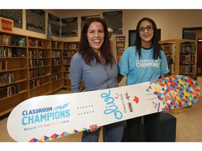 Navjot Munzal,14, with the snowboard she designed for Paralympian Michelle Salt as part of Classroom Champions pose for a photo at Dr. Gordon Higgins School in Calgary, Ab., on Friday February 5, 2016. Leah Hennel/Postmedia