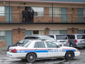 Police work at Red Carpet Inn and Suites in Calgary, Alta., after a woman was found dead inside a room there on Thursday, Feb. 18, 2016. The death was later ruled not suspicious.