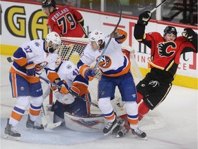 Sam Bennett of the Calgary Flames is knocked off his feet in front of New York Islanders goalie Jaroslav Halak during the second period at the Saddledome Thursday night February 25, 2016. In front of the net are Islanders defenders Brian Strait, 37, and Matt Martin while Micheal Ferland of the Flames is behind.