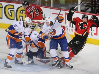 Sam Bennett of the Calgary Flames is knocked off his feet in front of New York Islanders goalie Jaroslav Halak during the second period at the Saddledome Thursday night February 25, 2016. In front of the net are Islanders defenders Brian Strait, 37, and Matt Martin while Micheal Ferland of the Flames is behind.