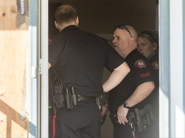 Police work inside a home in the 1800 block of 38 St NE in Calgary, Alta., on Sunday, Feb. 21, 2016. Early reports said shots had been fired into the home, but there was no early confirmation for media. Lyle Aspinall/Postmedia Network