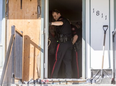 Police work inside a home in the 1800 block of 38 St NE in Calgary, Alta., on Sunday, Feb. 21, 2016. Early reports said shots had been fired into the home, but there was no early confirmation for media. Lyle Aspinall/Postmedia Network