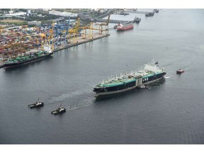 An aerial view taken from a helicopter shows a guided LNG tanker being towed along the Johor straits bordering Singapore.