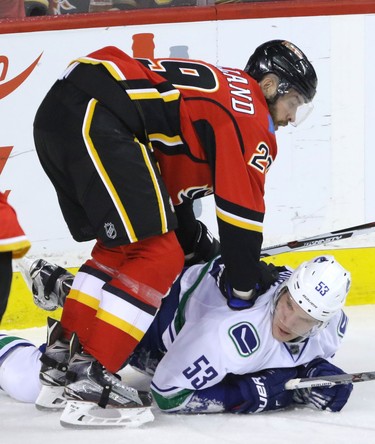 Calgary Flames Deryk Engelland takes down Vancouver Canucks Bo Horvat in NHL hockey action at the Dome in Calgary, Alta. on Friday February 19, 2016. Mike Drew/Postmedia