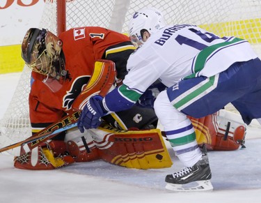 Calgary Flames goalie Jonas Hiller stops Vancouver Canucks Alexandre Burrows  in NHL hockey action at the Dome in Calgary, Alta. on Friday February 19, 2016. Mike Drew/Postmedia