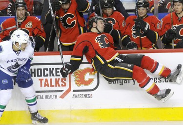 Calgary Flames Lance Bouma goes flying after hitting Vancouver Canucks Emerson Etem in NHL hockey action at the Dome in Calgary, Alta. on Friday February 19, 2016. Mike Drew/Postmedia