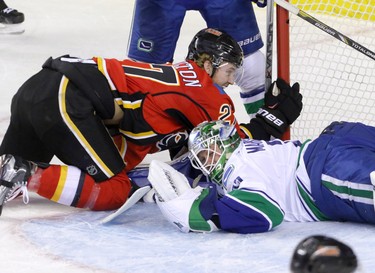 Calgary Flames Dougie Hamilton collides with Vancouver Canucks goalie Jacob Markstrom in NHL hockey action at the Dome in Calgary, Alta. on Friday February 19, 2016. Mike Drew/Postmedia