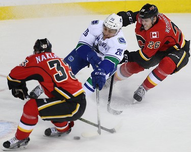 Calgary Flames Jakub Nakladal and Tyler Wotherspoon battle against Emerson Etem of the Vancouver Canucks during NHL hockey in Calgary, Alta., on Friday, February 19, 2016. Al Charest/Postmedia