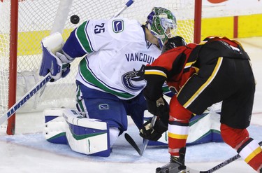 Calgary Flames Josh Jooris puts the puck past Vancouver Canucks Jacob Markstrom in NHL hockey action at the Dome in Calgary, Alta. on Friday February 19, 2016. The Flames beat the Canucks 5-2. Mike Drew/Postmedia