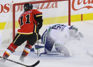 Calgary Flames Mikael Backlund is stopped by Vancouver Canucks Jacob Markstrom with teammate Lance Bouma in NHL hockey action at the Dome in Calgary, Alta. on Friday February 19, 2016. The Flames beat the Canucks 5-2. Mike Drew/Postmedia