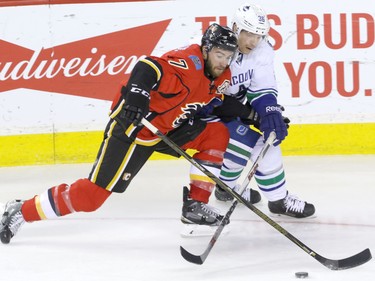 Calgary Flames TJ Brodie battles with Vancouver Canucks  Jannik Hansen in NHL hockey action at the Dome in Calgary, Alta. on Friday February 19, 2016. Mike Drew/Postmedia