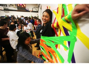 Grade 7 and 9 teacher Stefanie Rimban finds herself taped to the gymnasium wall Monday February 29, 2016 in the Stick it to Cancer fundraiser at St Helena Junior High. The school students and staff held the event, with a floor hockey game, head shaving and teachers being taped to the wall, in honour of grade nine student Alec Remenda who is battling cancer. (Ted Rhodes/Postmedia)
