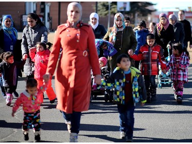 Syrian refugee women and their children make their way from the hotel where they're living to a local rec centre on Tuesday February 23, 2016.