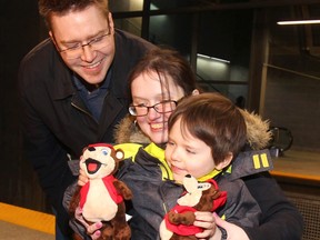 Kayden Petke, 4, shows toys from Calgary Transit to parents Daniel and Brittni.
