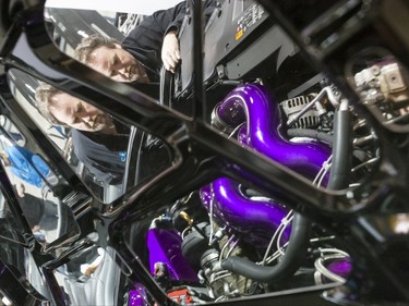 Trent Clark checks out the 1,900-horsepower engine inside his 2007 GMC pickup dubbed 'The Bear' at the World of Wheels show at the BMO Centre in Calgary, Alta., on Saturday, Feb. 20, 2016. The popular auto-enthusiast show is in its 50th year. Lyle Aspinall/Postmedia Network