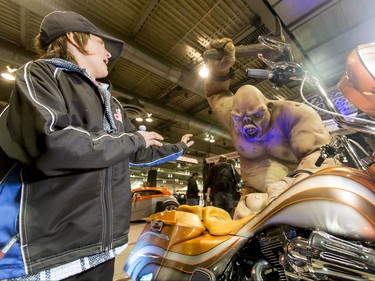 Connor McGovern, 12, checks out a monster near a Harley Davidson during the World of Wheels show at the BMO Centre in Calgary, Alta., on Saturday, Feb. 20, 2016. The popular auto-enthusiast show is in its 50th year. Lyle Aspinall/Postmedia Network