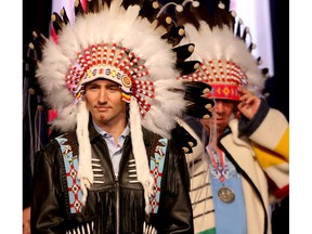 Prime Minister Justin Trudeau poses with his painted face  after being presented a headdress by Tom Heavenfire in an honouring ceremony at the Tsuut'ina Nation near Calgary.
