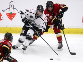 Calgary Inferno forward Blayre Turnbull, right, checked Brampton Thunder forward Elle Seedhouse during the CWHL game at Winsport on November 28, 2015.