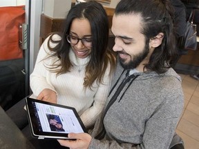 In this Tuesday, March 1, 2016, photo, Nicole DePinto, left, and her husband, Anthony, pose for a photo with their crowdfunding page displayed on an iPad, in New York. Websites such as Honeyfund, GoFundMe and Honeymoon Wishes make it easy to raise cash for a post-wedding getaway.