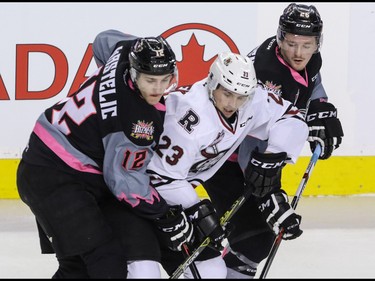 Calgary Hitmen Mark Kastelic and Andrew Fyten try to slow down Michael Spacek in WHL action at the Scotiabank Saddledome in Calgary, Alberta, on Sunday, March 6, Mike Drew/Postmedia