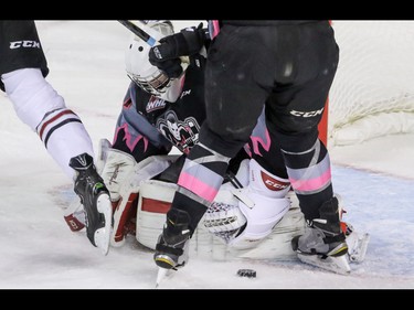 Calgary Hitmen goalie Cody Porter lost his stick and had to scramble for the puck among the skates against the Red Deer Rebels in WHL action at the Scotiabank Saddledome in Calgary, Alberta, on Sunday, March 6.  Mike Drew/Postmedia